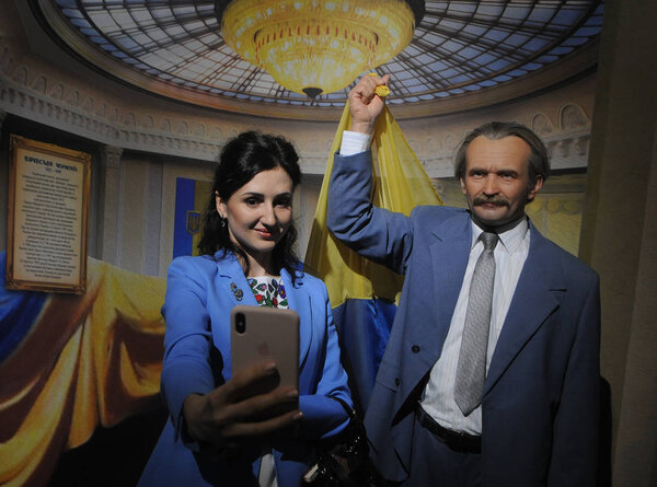 A woman takes a selfie against the background of the figure of the Ukrainian politician, dissident, Hero of Ukraine Vyacheslav Chernovol during the opening of the innovative museum "The Formation of the Ukrainian Nation", in Kiev, August 3, 2019.