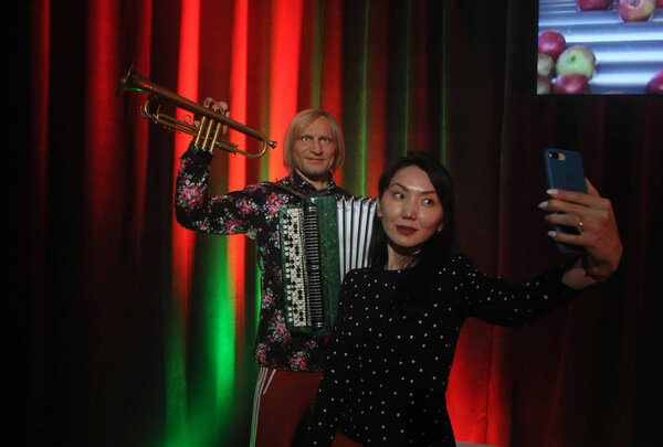 A woman takes a selfie against the background of the figure of the musician Oleg Skrypka during the opening of the innovative museum "The Formation of the Ukrainian Nation", in Kiev, August 3, 2019