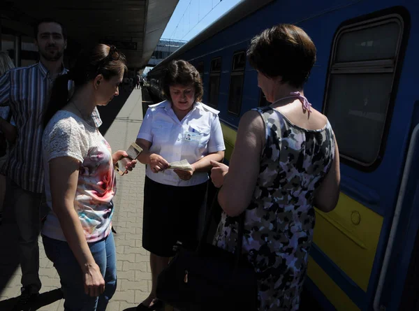 провідник поїзду на пероні перевіряє квитки