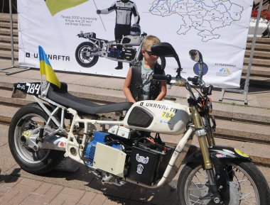 26 Haziran 2020 'de Kiev, Khreshchatyk' teki efsanevi Ukrayna yapımı elektrikli Dnepr elektrikli motosiklet yakınlarında bir çocuk..