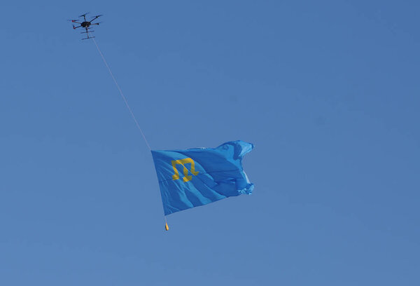 Crimean Tatar flag against the sky during a solemn procession to the Day of the Crimean Tatar flag, in Kiev, June 26, 2020