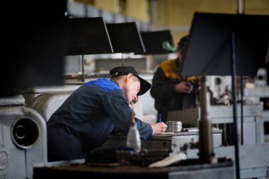Barnaul, Rusya Federasyonu-5 Şubat 2018. İşçi metal Beton ürünler fabrikada keser.