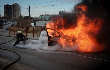 Barnaul, Rusya Federasyonu-Ekim 12, 2018. İtfaiyeciler yanan bir arabadan söndürmek