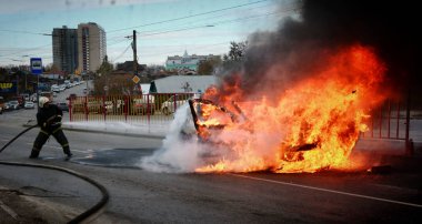 Barnaul, Rusya Federasyonu-Ekim 12, 2018. İtfaiyeciler yanan bir arabadan söndürmek