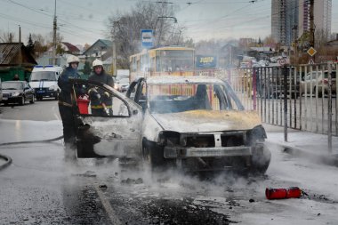 Barnaul, Rusya Federasyonu-Ekim 12, 2018. İtfaiyeciler yanan bir arabadan söndürmek
