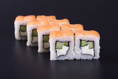 Karanlık bir arka plan üzerinde deniz ürünleri ile Japon rulo