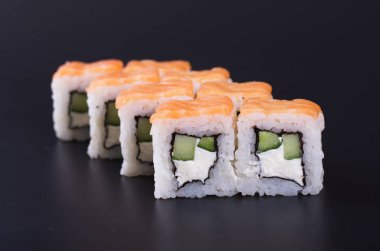 Karanlık bir arka plan üzerinde deniz ürünleri ile Japon rulo