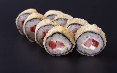 Karanlık bir arka plan üzerinde deniz ürünleri ile Japon rulo