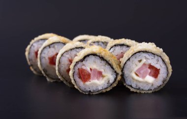 Karanlık bir arka plan üzerinde deniz ürünleri ile Japon rulo