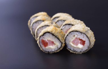 Karanlık bir arka plan üzerinde deniz ürünleri ile Japon rulo