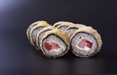 Karanlık bir arka plan üzerinde deniz ürünleri ile Japon rulo