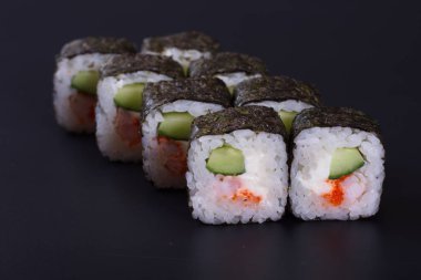 Karanlık bir arka plan üzerinde deniz ürünleri ile Japon rulo