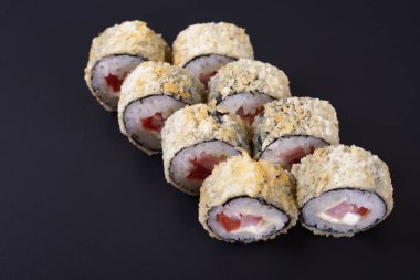 Karanlık bir arka plan üzerinde deniz ürünleri ile Japon rulo