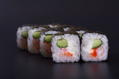 Karanlık bir arka plan üzerinde deniz ürünleri ile Japon rulo