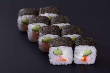 Karanlık bir arka plan üzerinde deniz ürünleri ile Japon rulo