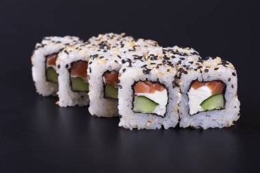 Karanlık bir arka plan üzerinde deniz ürünleri ile Japon rulo