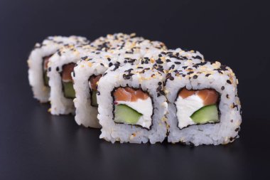 Karanlık bir arka plan üzerinde deniz ürünleri ile Japon rulo
