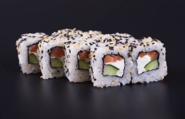 Karanlık bir arka plan üzerinde deniz ürünleri ile Japon rulo