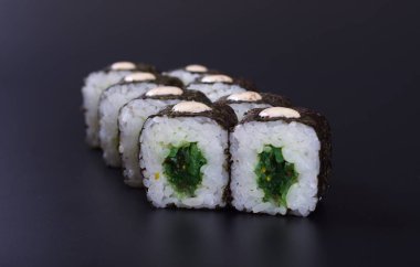 Karanlık bir arka plan üzerinde deniz ürünleri ile Japon rulo