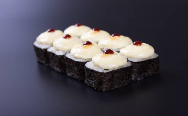 Karanlık bir arka plan üzerinde deniz ürünleri ile Japon rulo