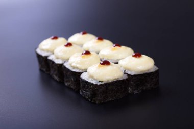 Karanlık bir arka plan üzerinde deniz ürünleri ile Japon rulo