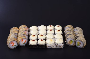 Karanlık bir arka plan üzerinde deniz ürünleri ile Japon rulo