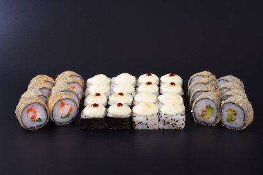 Karanlık bir arka plan üzerinde deniz ürünleri ile Japon rulo