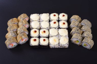 Karanlık bir arka plan üzerinde deniz ürünleri ile Japon rulo