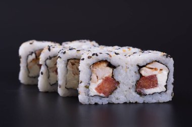 Karanlık bir arka plan üzerinde deniz ürünleri ile Japon rulo