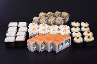 Karanlık bir arka plan üzerinde deniz ürünleri ile Japon rulo