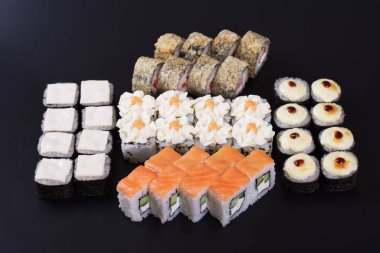 Karanlık bir arka plan üzerinde deniz ürünleri ile Japon rulo