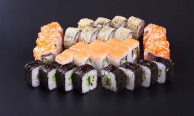 Karanlık bir arka plan üzerinde deniz ürünleri ile Japon rulo