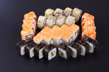 Karanlık bir arka plan üzerinde deniz ürünleri ile Japon rulo