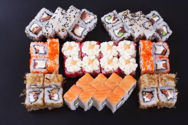 Karanlık bir arka plan üzerinde deniz ürünleri ile Japon rulo