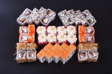 Karanlık bir arka plan üzerinde deniz ürünleri ile Japon rulo