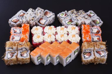 Karanlık bir arka plan üzerinde deniz ürünleri ile Japon rulo