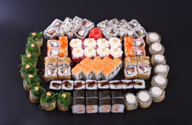 Karanlık bir arka plan üzerinde deniz ürünleri ile Japon rulo