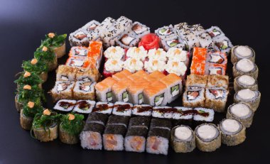 Karanlık bir arka plan üzerinde deniz ürünleri ile Japon rulo