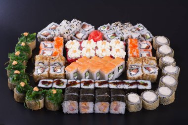 Karanlık bir arka plan üzerinde deniz ürünleri ile Japon rulo