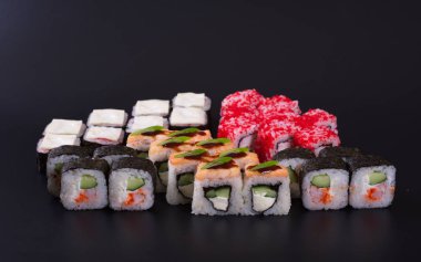 Karanlık bir arka plan üzerinde deniz ürünleri ile Japon rulo