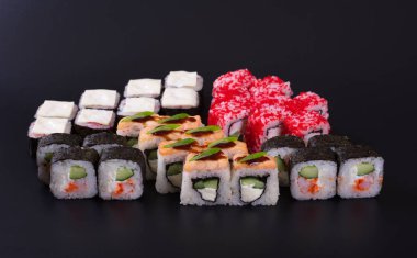 Karanlık bir arka plan üzerinde deniz ürünleri ile Japon rulo