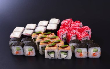 Karanlık bir arka plan üzerinde deniz ürünleri ile Japon rulo