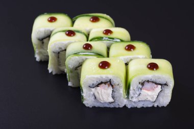 Karanlık bir arka plan üzerinde deniz ürünleri ile Japon rulo