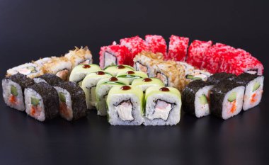 Karanlık bir arka plan üzerinde deniz ürünleri ile Japon rulo