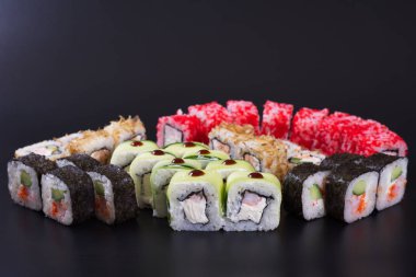 Karanlık bir arka plan üzerinde deniz ürünleri ile Japon rulo