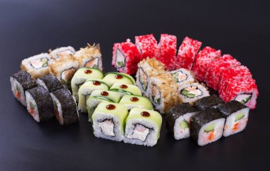 Karanlık bir arka plan üzerinde deniz ürünleri ile Japon rulo