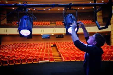 Barnaul, Rusya-21 Mart 2018. ışık sanatçısı tiyatroda aydınlatma armatürleri bağlar