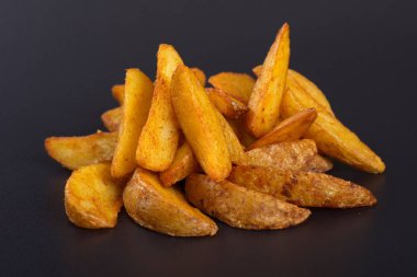 Pişmiş sarı patates dilimleri koyu bir arka plan üzerinde yalan