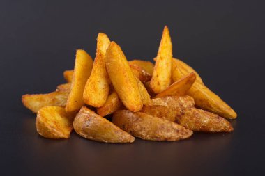 Pişmiş sarı patates dilimleri koyu bir arka plan üzerinde yalan