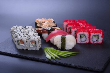 Japon mutfağından deniz ürünleriyle dolu renkli börekler koyu bir arka planda yatar.